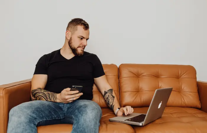 Mann arbeitet an einem Ledersofa