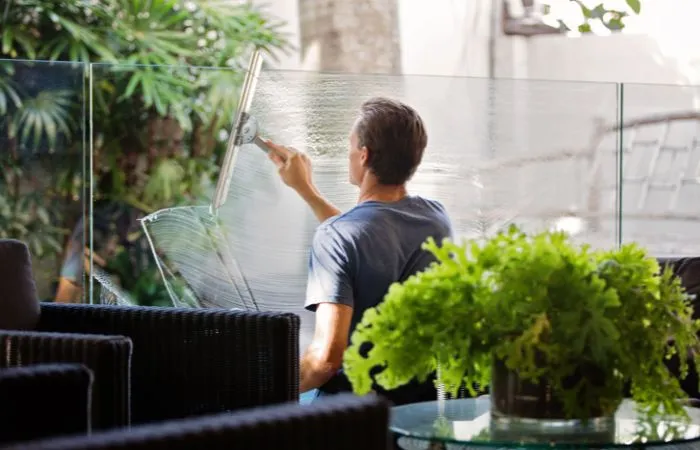 Una fase della pulizia dei vetri con uno strumento adatto