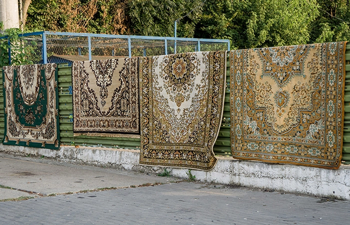 Una fase di asciugatura del tappeto persiano pulito con un panno appena inumidito