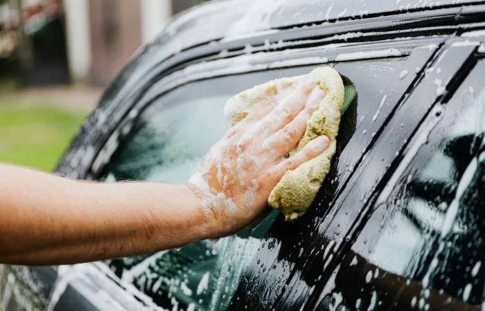 Una spugna con un detergente per auto