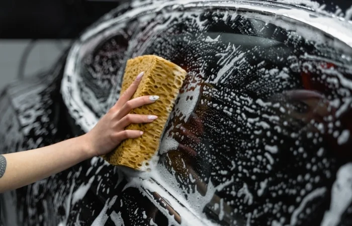 Una spugna e del detergente multiuso per la pulizia dei vetri dell'auto